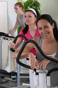 妇女在体育馆锻炼女性蒸腾工作福利眼线笔健身房出汗仪器跑步机微笑图片