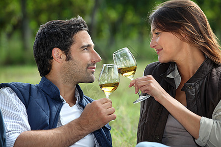 一对夫妇在野外喝酒生长生产女士酿酒师葡萄园水果藤蔓收成眼镜庆典图片