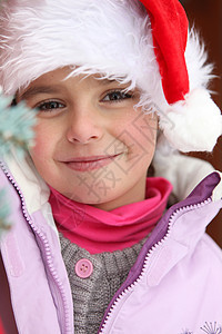 戴着圣诞老人帽子的小女孩女性说谎传统喜悦装饰品季节乐趣庆典女孩童年图片