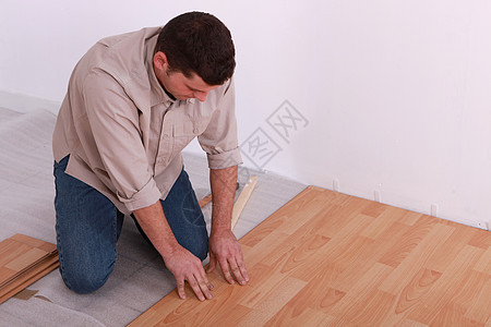 男人在木地板上铺木地板压板修理装修装潢牛仔裤工人建设者房子木头层压图片