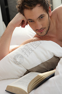 年轻人在床上看书背景图片