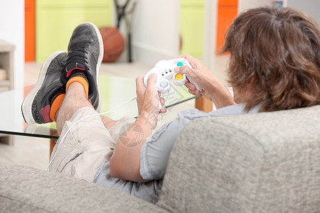 玩电子游戏的青少年沙发长椅乐趣男性视频控制技术青春期游戏时间图片