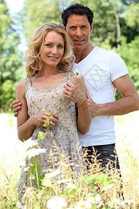 丈夫与妻子身边的手农村男人棕色微笑金发白色女性拥抱个人雏菊图片