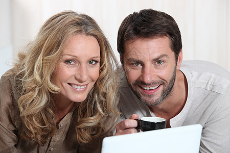 夫妇在笔记本电脑上微笑头发女性女士男人金发个人丈夫白色妻子男性图片