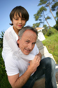 小男孩坐在他父亲的肩膀上图片