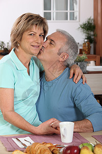 夫妇亲吻妻子咖啡快乐微笑女士男人互动笑声女性厨房图片