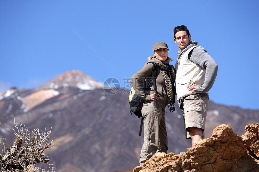 一对夫妇在山上徒步旅行微笑快乐岩石摄影天空背包喜悦夫妻冒险成人图片