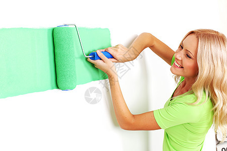 妇女在墙上涂油漆房子快乐艺术微笑设计师蓝色画家工具女孩项目图片