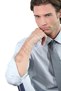 年轻商务人士靠在椅子上领带衬衫白色倾斜蓝色实习生眼睛套装男性棕色图片