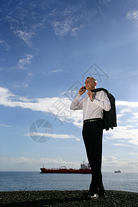 男人在电话上 在海面前面图片