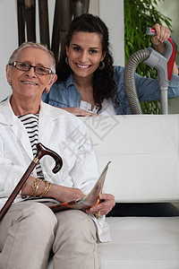 帮助一位年长女士做家务的年轻妇女图片