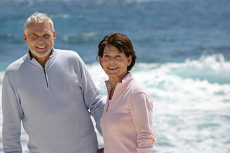 享受在海滩上散步的老年夫妇图片
