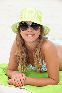 美丽的女孩在海滩晒日光浴图片