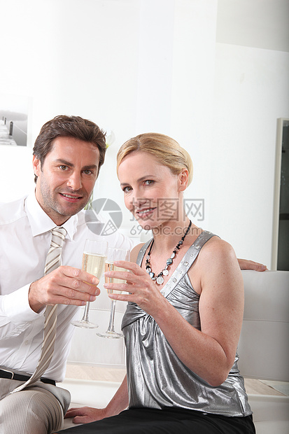 来一杯香槟庆祝一对情侣男性微笑男人衬衫妻子玻璃领带纪念日金发头发图片