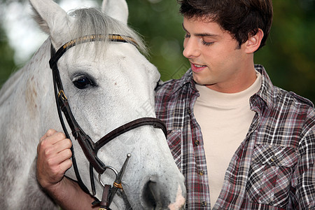 带马的年轻人骑术鼻孔乡村绳索宠物工人运动白色鬃毛牛仔图片