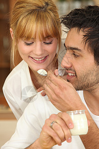 男人给他的女朋友喂一汤匙酸奶图片