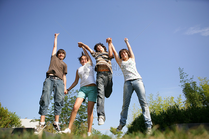 一群手握手并跳上空中的青少年图片