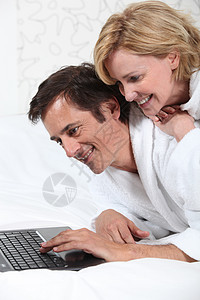 在笔记本电脑上的情侣 穿礼服男人个人妻子棕色配置男性丈夫女性浴衣金发图片