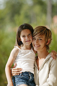 母亲和女儿在公园里微笑农村花园拥抱女性感情家庭两个人亲热孩子背景图片