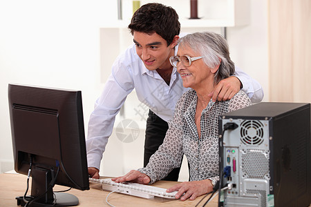 一位年轻男子和年长妇女肖像帮助房子工作电脑新技术拥抱服务眼镜修理男人图片