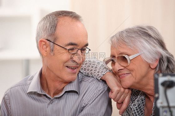 在家微笑的老年夫妇讲话投标佩戴者互联网桌面技术幸福眼镜沙发退休图片