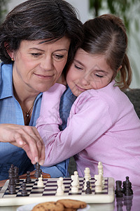 一个祖母和她孙女在下象棋图片