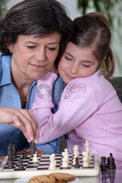 一个祖母和她孙女在下象棋图片