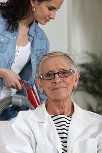 帮助年长妇女做家务的年轻女青年图片