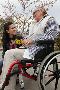 年青妇女与一名坐轮椅的老年妇女图片