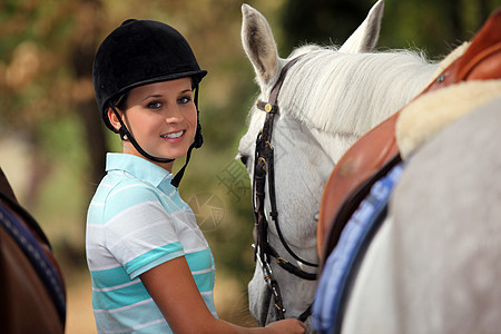 照顾马匹的年轻女子友谊宠物牧场天空日落幸福马术女性骑士情感图片