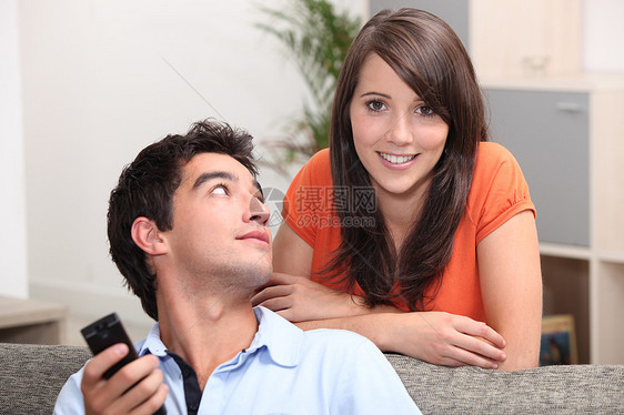 年轻夫妇在看电视个人男人女孩电视前房朋友们保姆交换电视机长椅图片