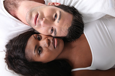 床上的年轻夫妇爆炸多样性压痛情人男人白色黑色幸福女士卧室图片