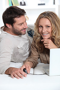 丈夫看妻子棕色男人白色头发笔记本金发男性女士微笑电脑图片