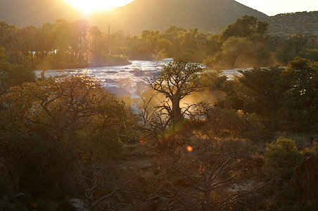 Epupa瀑布日出 纳米比亚洪水戏剧性峡谷巨石太阳阴影悬崖日落急流彩虹图片