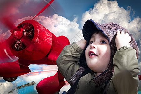 一个可爱的男婴在一架红色飞机上把他的手放在他的身上图片
