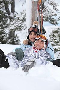 一对夫妇在滑雪途中躺下图片