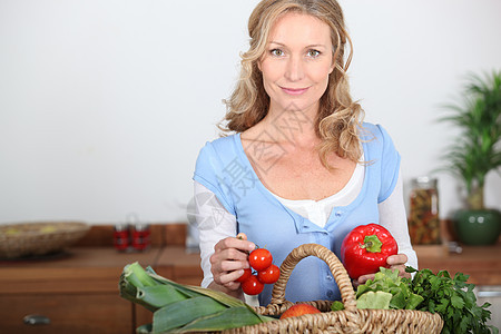 怀着胡椒和西红柿的妻子食物夫妻女性白色蔬菜幸福微笑福利厨房头发图片
