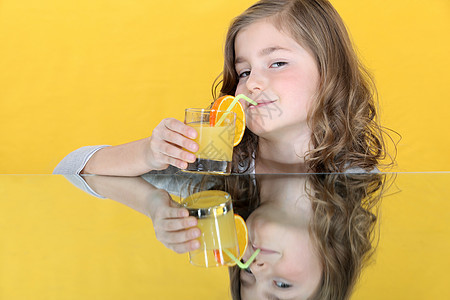 喝橙汁的小女孩童年白色金发女孩营养果汁玻璃桌子孩子食物图片