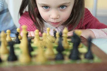 女孩下象棋学习战略棕色快乐眼睛智力女王专注孩子思维图片
