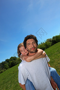 男人背着小女孩在草地上骑着小姑娘图片