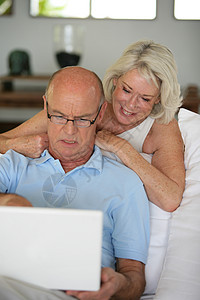 年长夫妇坐在沙发上上网冲浪图片