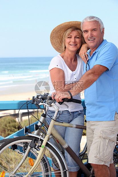 在海滩边骑自行车的成熟夫妇图片
