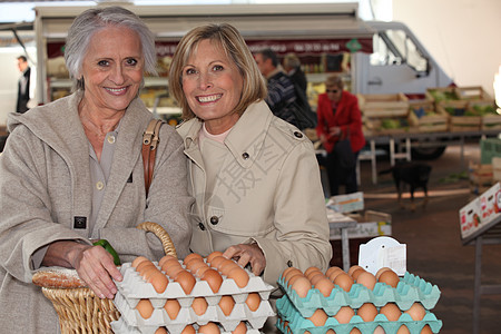 母亲和女儿在市场上买鸡蛋图片