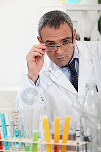 科学家在实验室的测试管后面触摸他的眼镜图片