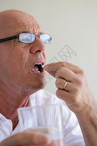 老人吞吃药丸背景图片