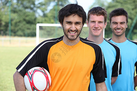 3名足球运动员在球前排队图片