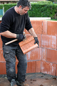 工作场所的造房者瓦工建筑工作服男人建设者锤子工业工具房子石工图片