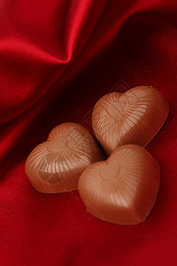 红沙子上的糖果心小吃甜点金子丝带巧克力织物正方形标签庆典盒子图片