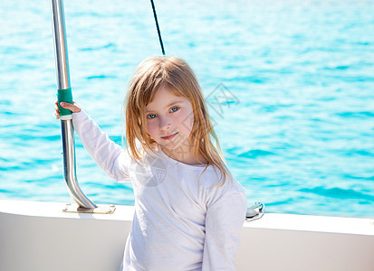 金发小金发女孩 在船上航行 微笑的船海浪眼睛运输童年假期游艇导航海洋帆船孩子图片