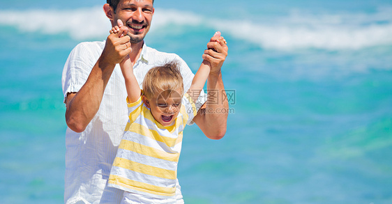 父子在沙滩上玩得开心乐趣海洋假期孩子海滩男人父母男性幸福家庭图片